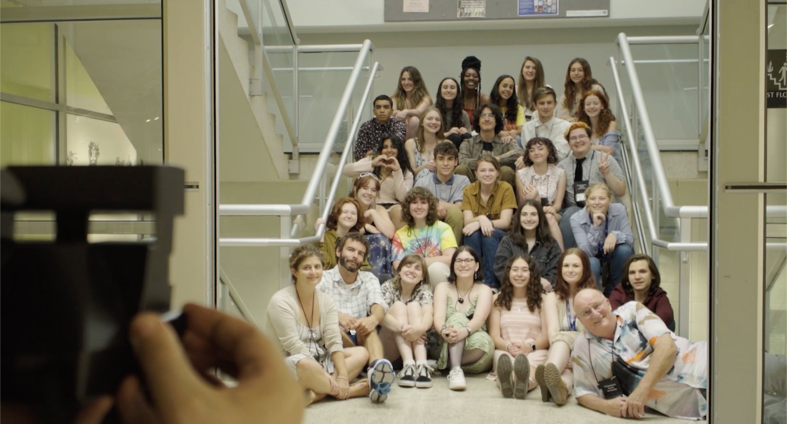 The Governor's School film students gathered on a stairwell, a camera in the foreground