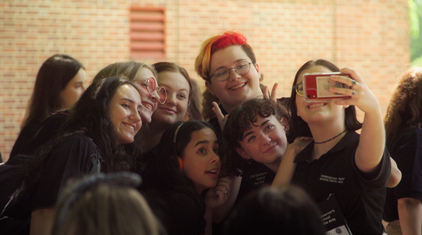 A group of students crowded together for a selfie, smiling