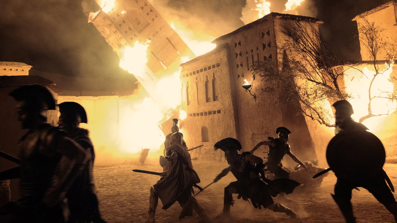 Spears silhouetted against a burning town in Christopher Nolan's The Odyssey